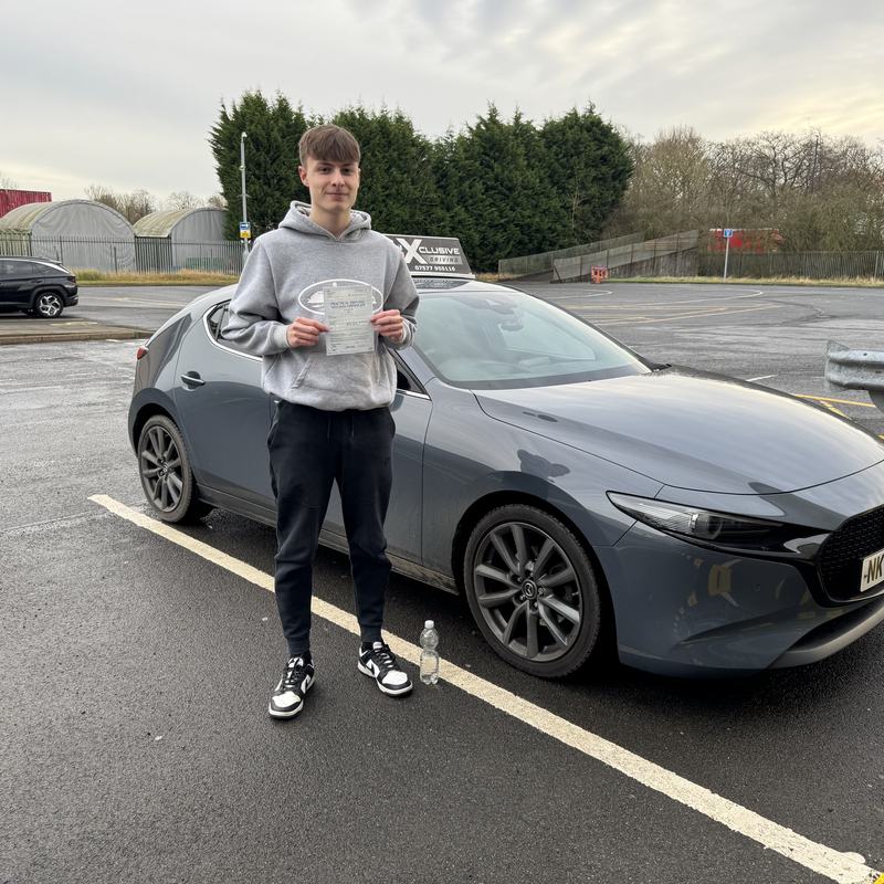An Xclusive Driving student holding their practical driving test pass certificate after passing